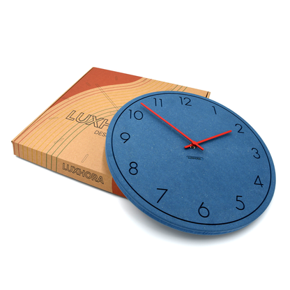 LUXHORA Numera Wanduhr in Valchromat Blau vor ihrer Verpackung